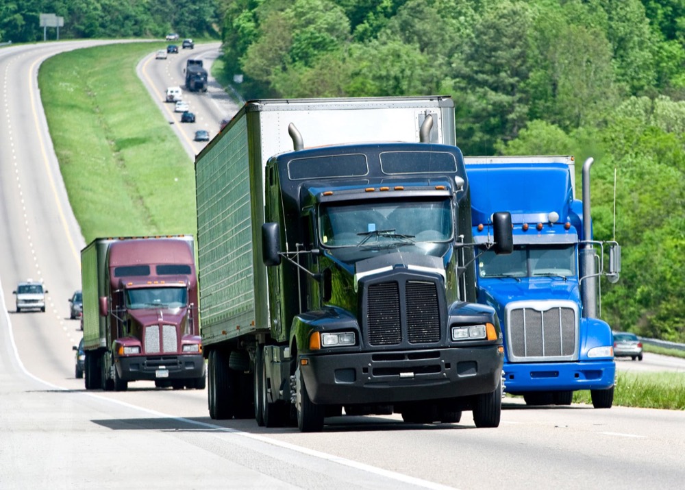 Row of semi trucks staged at a freight terminal